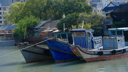 Obraz premium The blue fishing boat is docked at the small fishing port
