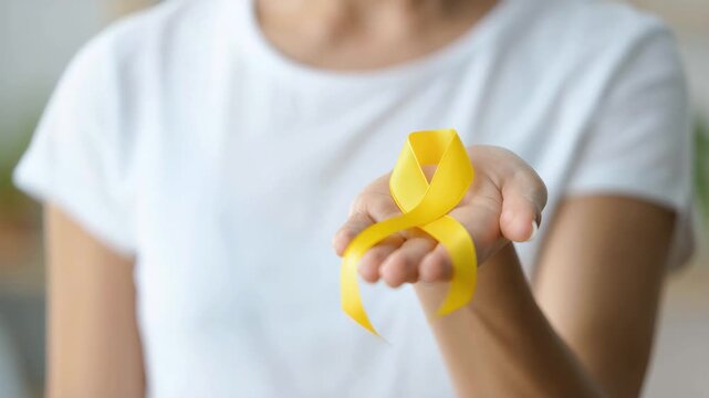 Endometriosis awareness yellow ribbon held forward, supporting living with pelvic pain, infertility and pain, advocacy for diagnosis delays, surgical options and care, education, journeys