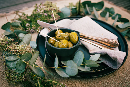 Green olives in an aromatic herb marinade. Mediterranean-table decoration for a appetizer.
