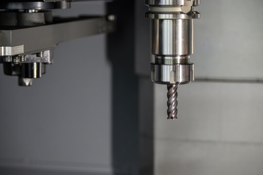 Close-up of a flat nose end mill secured in a high-precision tool holder attached to a CNC machine spindle.