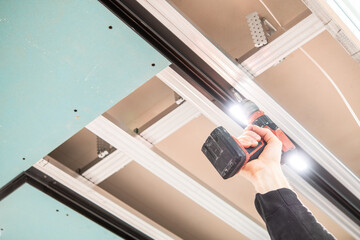 Fototapeta premium Installation of Suspended Ceiling with Track Lighting and LED Lights