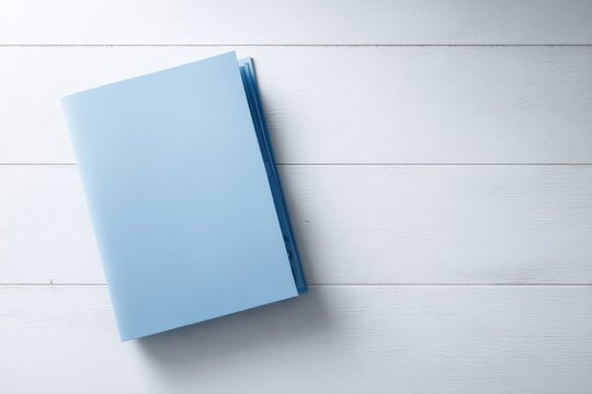 A single blue medical folder on a white desk, top-down view, plenty of empty desk space around it