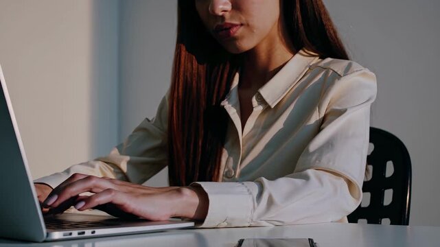 Typing laptop shows cybersecurity hologram. Woman types while lock floats above screen. Visualization shows data security and encryption. Image conveys privacy and technology. Data flow visible now.