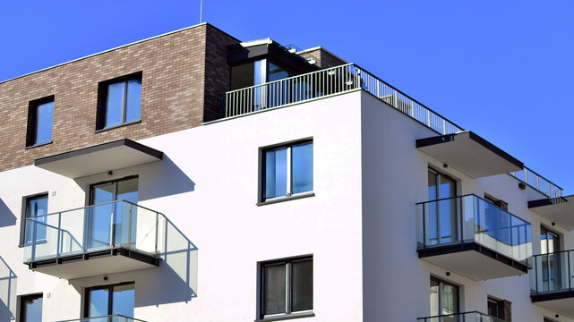 Modern apartment buildings on a sunny day with a blue sky. Facade of a modern apartment building. Glass surface with sunlight.