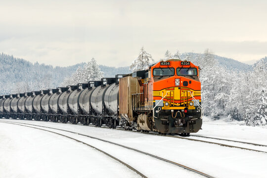 winter scene of a freight train pulling tanker cars near Whitefish, Montana