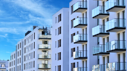 Fototapeta premium Modern apartment buildings on a sunny day with a blue sky. Facade of a modern apartment building. Glass surface with sunlight.
