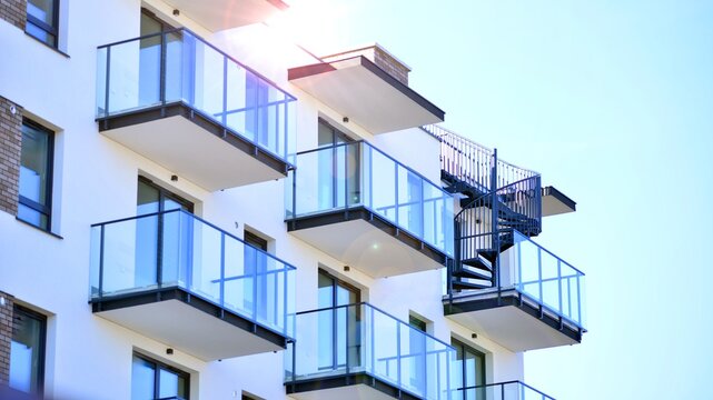 Modern apartment buildings on a sunny day with a blue sky. Facade of a modern apartment building. Glass surface with sunlight.