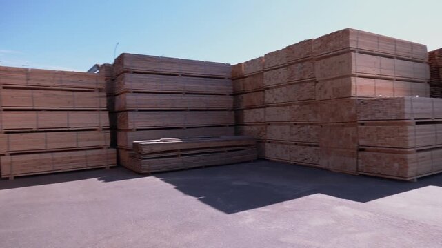 Timber mill. sawmill: storage of planed wooden boards. Folded edged board. Wood harvesting workshop. Stackable wooden boards in woodworking industry. Stacks with pine lumber.