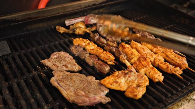 Mixed Grill and Steak Cooking on Open Flame Grill in Restaurant Kitchen