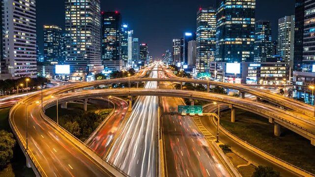 Night view of a futuristic urban highway interchange with fast-moving traffic light trails, symbolizing global connectivity, modern metropolitan life, and advanced transportation infrastructure for...