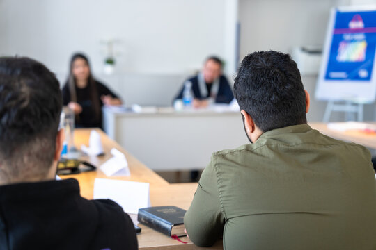 Group Bible study session with open scriptures on table, people reading and discussing faith, spirituality, and religious learning together in a peaceful indoor environment.