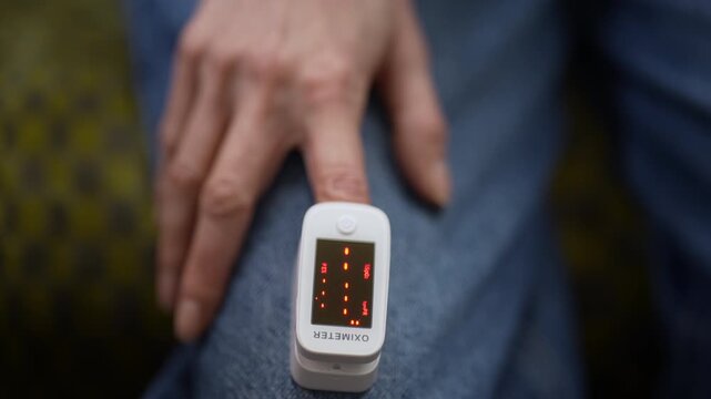 Person checking blood oxygen level with fingertip pulse oximeter device