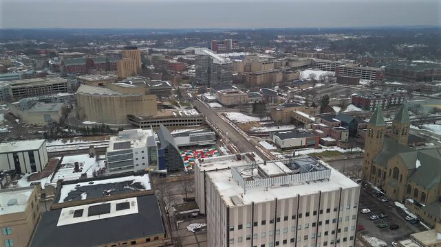 Drone aerial over downtown Akron Ohio with church towers streets and winter cityscape