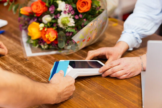 Florist accepting credit card payment for bouquet of flowers