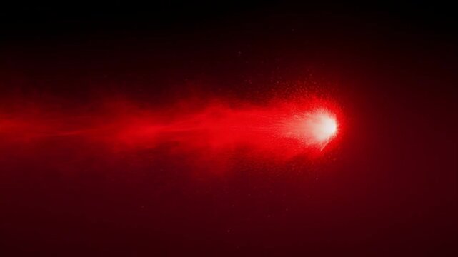 Bright red comet or particle stream moving through a dark red space