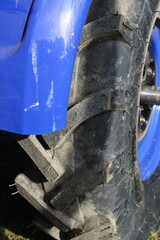 Close Look at a Large Blue Tractor Tire on a Farm During Daytime Near the Fields in Autumn Season
