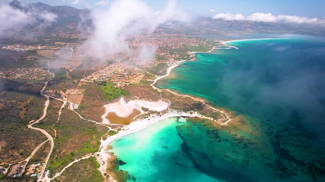 Sardinia Isuledda Beach aerial view through clouds over turquoise sea white sand and salt lagoon Caribbean water travel destination Italy San Teodoro Gallura coast cinematic drone footage 4k