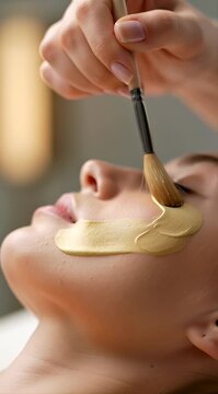 A person applies a face mask using a brush in a relaxing setting