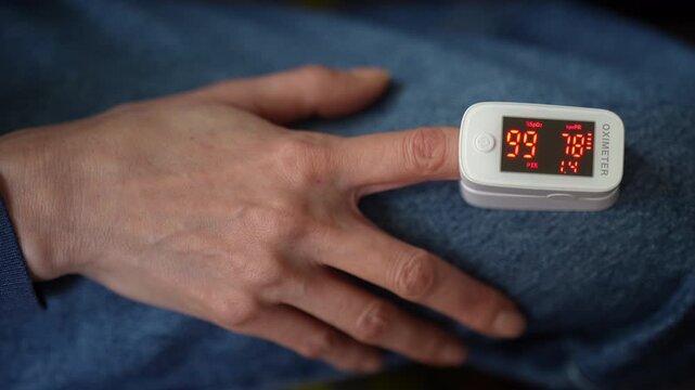 Close up fingertip pulse oximeter monitoring blood oxygen level