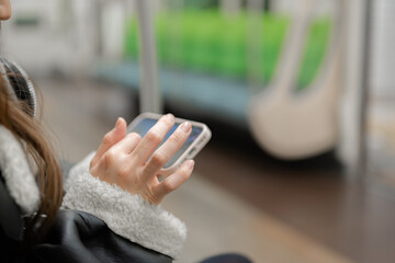 電車内でスマートフォンを使う女性 © Peak River