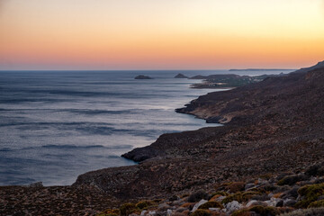 Rocky coastline and Mediterranean sea at sunset near Kato Zakros on southern coast of Crete Greece with colorful evening sky