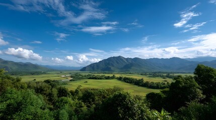 Fototapeta premium Expansive scenic landscape featuring rolling green hills a winding river majestic mountains under a bright blue sky with clouds