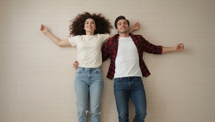 Obraz premium Top view of a young couple lying on a wooden floor. Happy man and woman relaxing in a new home. Togetherness and relaxation concept