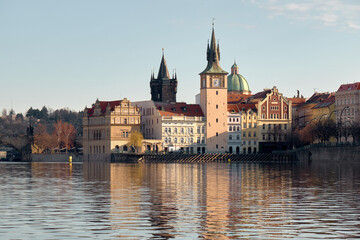 Fototapeta premium Charles Bridge and Vltava River reflecting historic Prague skyline at sunrise