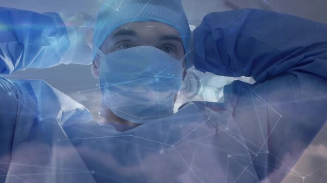 Surgeon preparing for surgery pulling mask straps, securing cap, adjusting gown under cloud overlay
