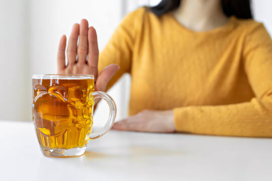 Woman declining alcoholic drink at home