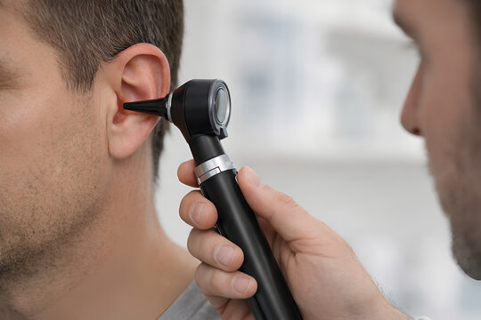 Photorealistic clinical macro close-up of an adult outer ear and canal entrance: clinician&rsquo;s gloved hand holding generic forceps near the ear opening, insect implied/partially visible without graphic