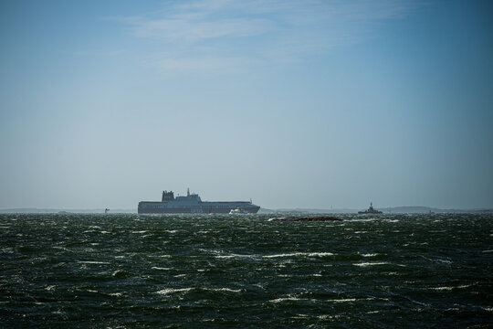 Gothenburg, Sweden - June 29 2025: DFDS cargo ship moving through distant misty sea.