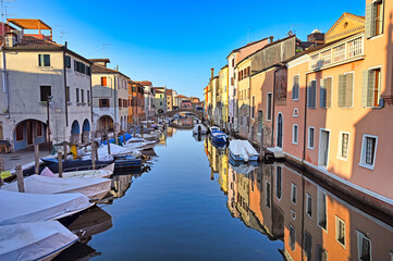 Obraz premium Chioggia cityscape with narrow water canal Vena with moored multicolored boats between old colorful buildings,Veneto Region, Italy