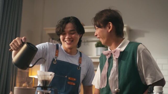 Happy young Asian gay couple homosexual making drip coffee together at modern kitchen in morning.Concept of LGBTQ diversity,morning routine,pride month,domestic lifestyle,LGBTQ+ Couple - relationship