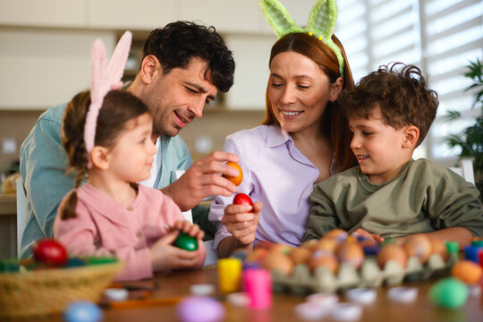 Parents and children decorating easter eggs together