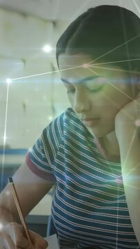 Vertical video: Teen lowering gaze, writing with pencil as nodes sweeping boosting learning focus