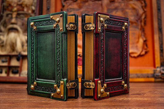 vintage leather books in different colors on the table with art in the background 