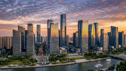 Obraz premium Modern glass skyscraper skyline glowing in warm sunset light above riverfront city, futuristic metropolitan skyline travel background
