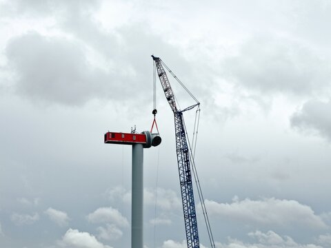 Schwerlastkran montiert Rotornabe an eine Windkraftanlage, Luftbild, Montage, Windpark, Hochbau, erneuerbare Energien, Windenergie, Aufbau eines Windrads, Energiewende