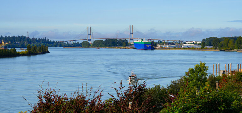Alex Fraser Bridge aka Annacis Bridge spanning the Fraser River in Delta behind a carship terminal in the Greater Vancouver metropolitan area, British Columbia, Canada