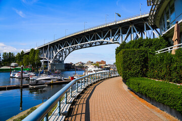 Waterfront promenade passing under Granville Street Bridge, a steel truss bridge spanning False Creek in Vancouver, British Columbia, Canada © Alexandre ROSA