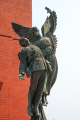 Naklejka premium Bronze statue of a dead Canadian soldier of the First or Second World Wars carried by an Angel in front of the Waterfront Station in Downtown Vancouver, British Columbia, Canada