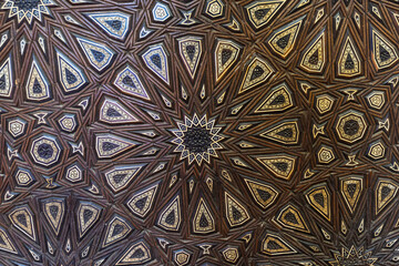 Ornate carved wood ceiling with geometric star pattern in historic Cairo, Egypt mosque architecture