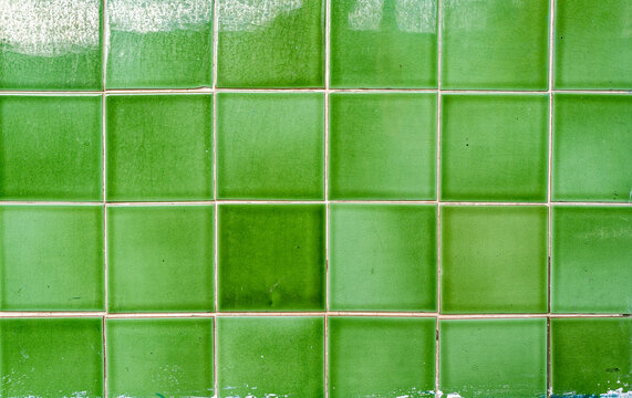 Detail of  green tiles lining the exterior wall of a building