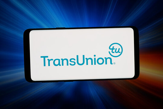 Stuttgart, Germany - 03-04-2026: In this photo illustration, the logo of consumer credit reporting agency TransUnion is displayed on a smartphone in front of abstract background on computer screen.