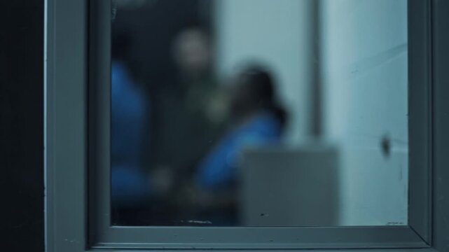 Female prisoner in a blue uniform leaving a visiting room through a secured door