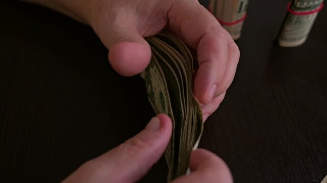 Elderly Person Counting Small Dollar Bills at Home