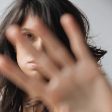 Frau h&auml;lt die Hand vor die Kamera als Stop-Geste. Ausdrucksstarkes Portr&auml;t f&uuml;r Themen wie Grenzen setzen, Nein sagen, Schutz, Selbstbestimmung und pers&ouml;nliche Abgrenzung.