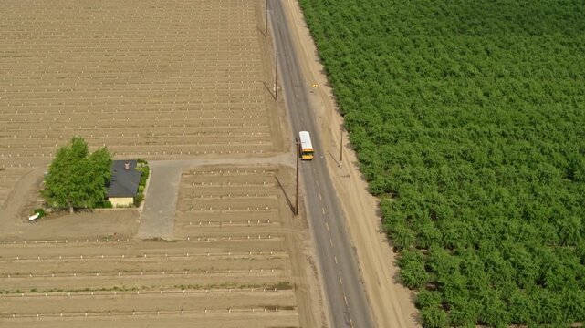 Aerial shot of a correctional facility bus transporting female prisoners through agricultural fields