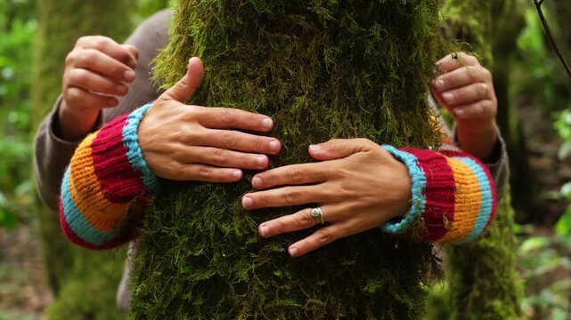 Couple hugging moss-covered tree trunk in lush forest, hands touching. Outdoor adventure and eco-experience concept highlighting love, wellbeing, nature immersion, mindfulness, and sustainable engagem